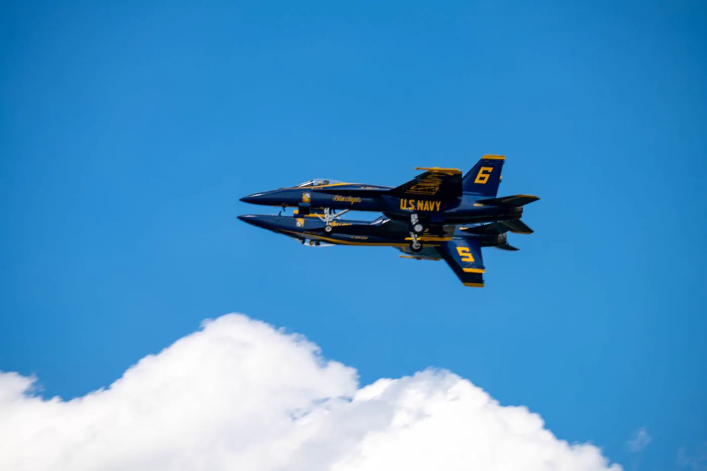 Blue Angels jets flying in close formation, mirror maneuver